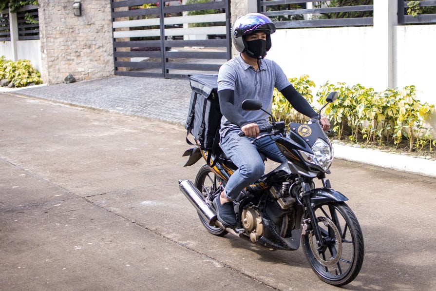 Delivery Man Riding on his Motorcycle 